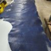 Blue leather hide laid out on table.