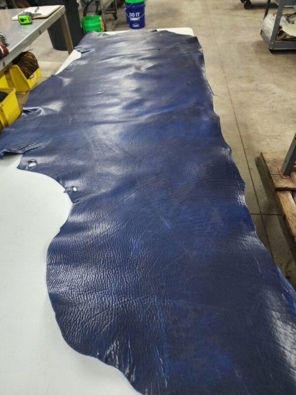 Blue leather hide laid out on table.