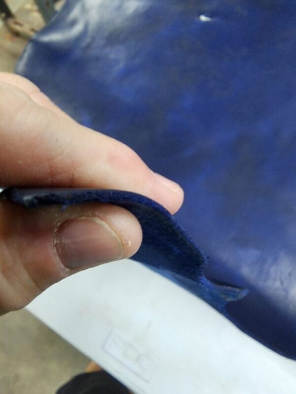 Hand holding a piece of blue fabric.