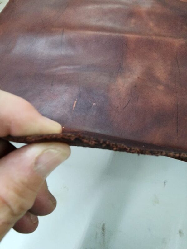 Close-up of brown leather edge in hand.