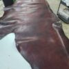 Brown leather hide laid out on surface.