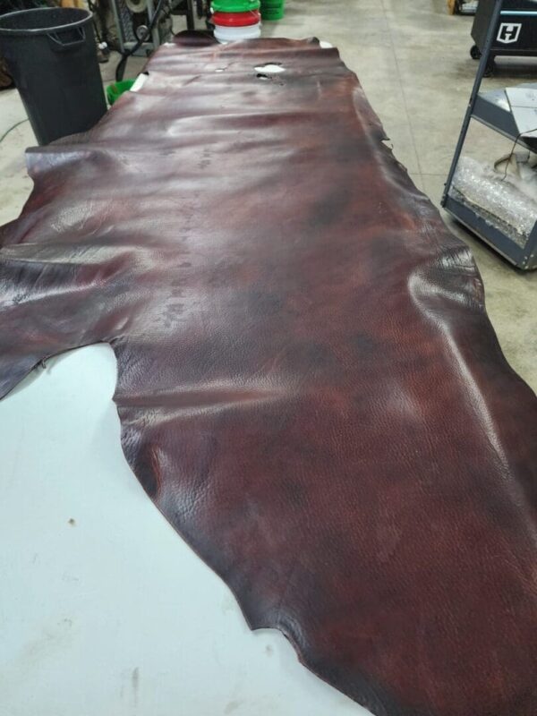 Brown leather hide laid out on surface.