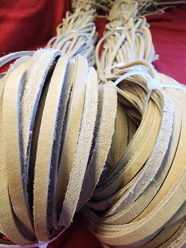 Leather strips stacked on a red background.