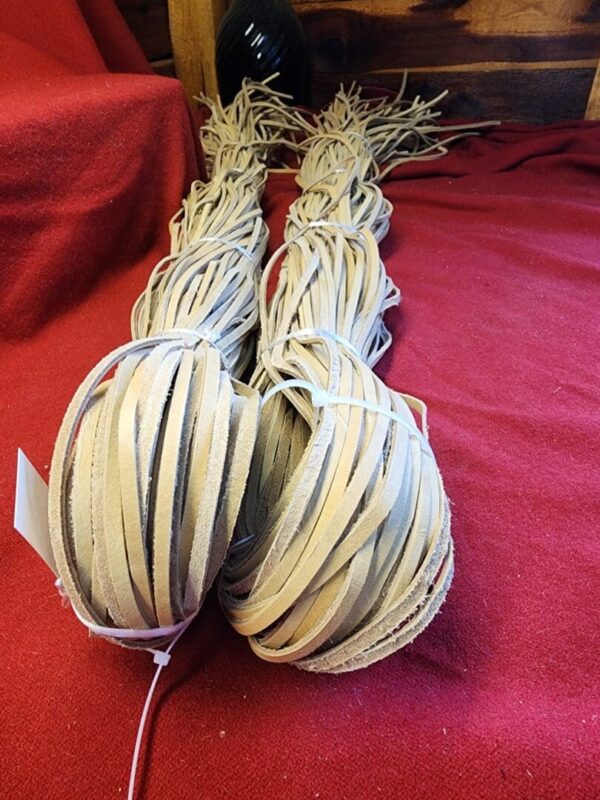 Two bundles of leather strips on fabric.