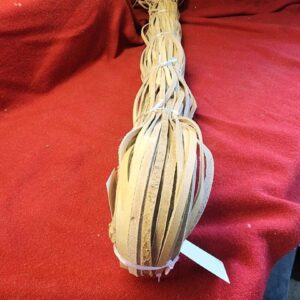 20240627_170345 Braided leather strips on a red surface.