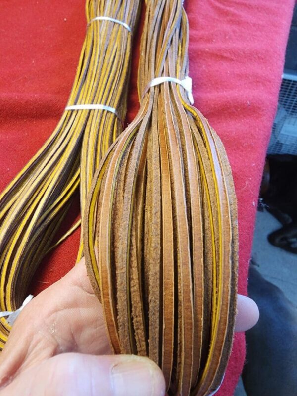 Hand holding multiple strips of leather.