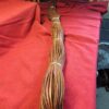 Coiled brown leather strip on red fabric.