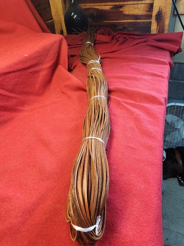 Coiled brown leather strip on red fabric.