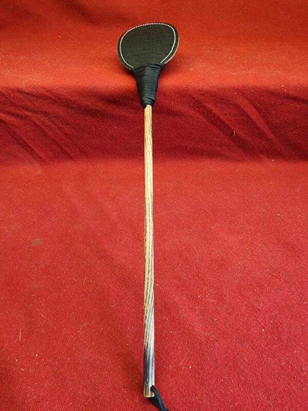 20240629_134429 Wooden paddle with a black fabric surface.