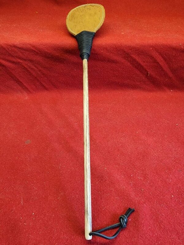 20240629_134437 Wooden stick with leather paddle at top.