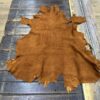 Brown leather hide on wooden table.