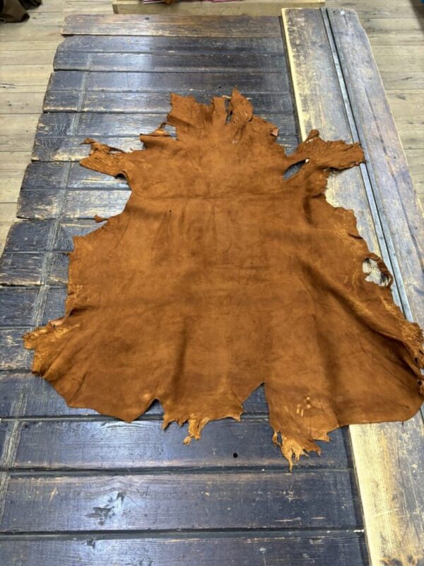 Brown leather hide on wooden table.
