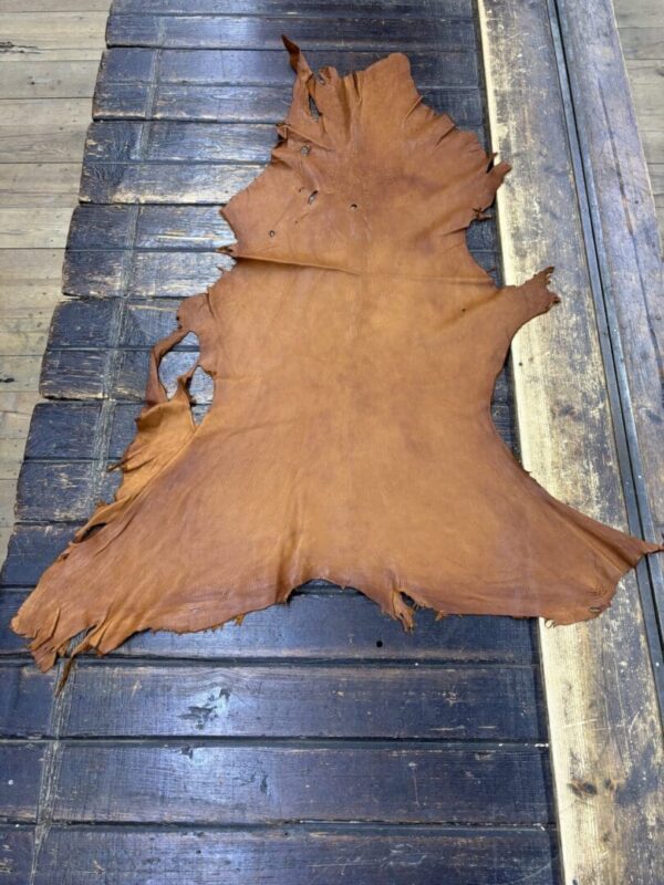 Brown leather hide on wooden surface.