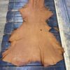 Tan leather hide on wooden surface.