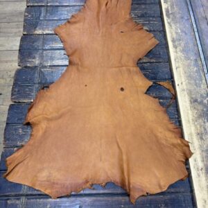 IMG_1870 Tan leather hide on wooden surface.