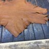 Brown leather hide on wooden surface.