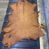 Brown leather hide on wooden table.