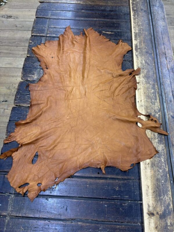 Brown leather hide on wooden table.
