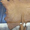 Tanned leather hide on wooden surface.