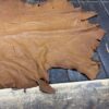 Brown leather hide on wooden table surface.
