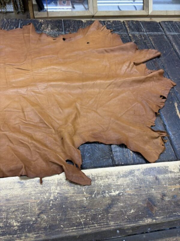 Brown leather hide on wooden table surface.