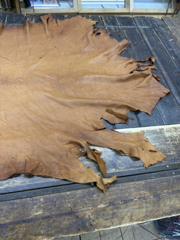 Leather hide spread on wooden table.