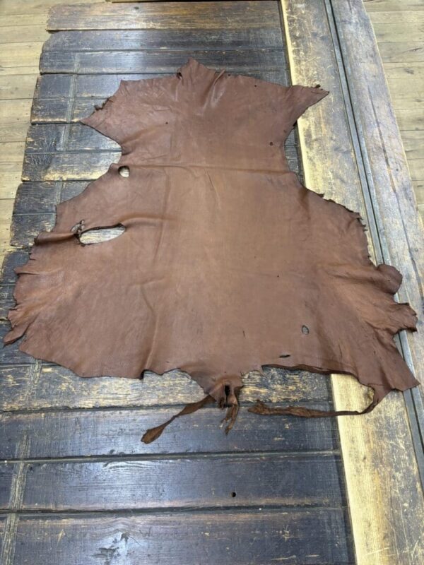 IMG_1888 Brown leather hide on wooden surface.