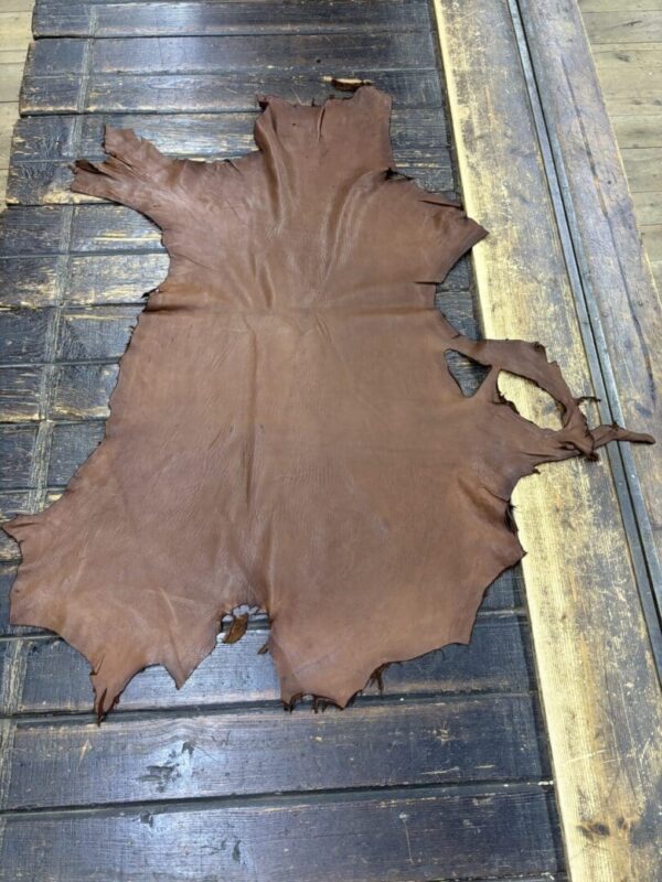 Brown leather hide on wooden surface.