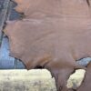 Brown leather hide on wooden surface.