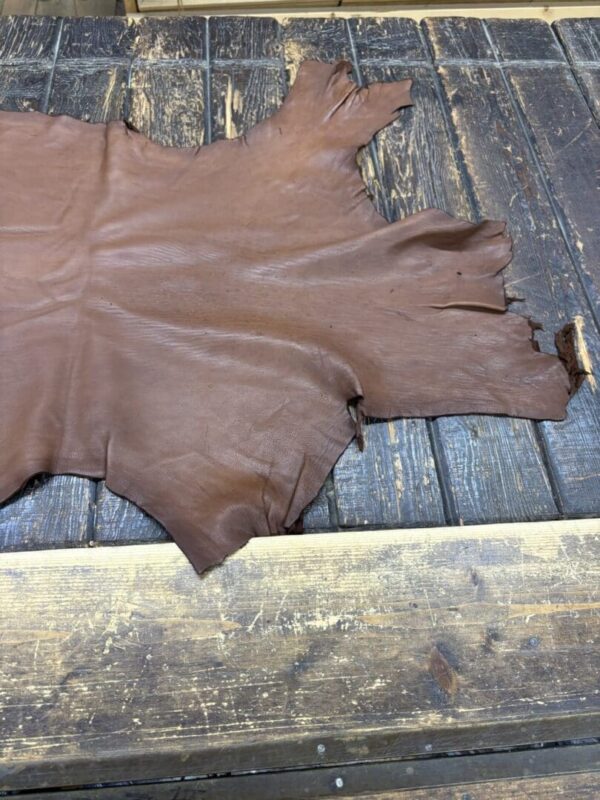 Brown leather hide on wooden surface.