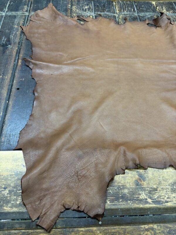 IMG_1897 Brown leather hide on wooden surface.