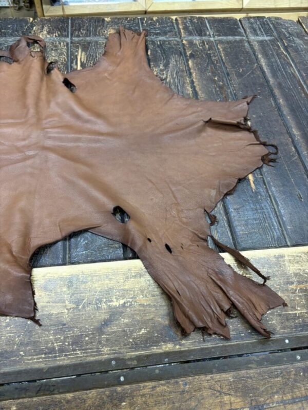 IMG_1898 Brown leather hide on wooden surface.