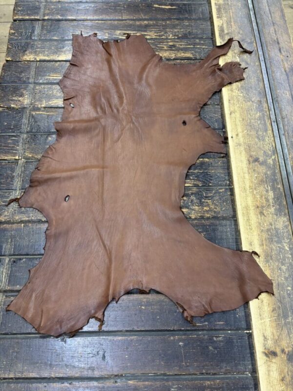 Brown leather hide on wooden surface.