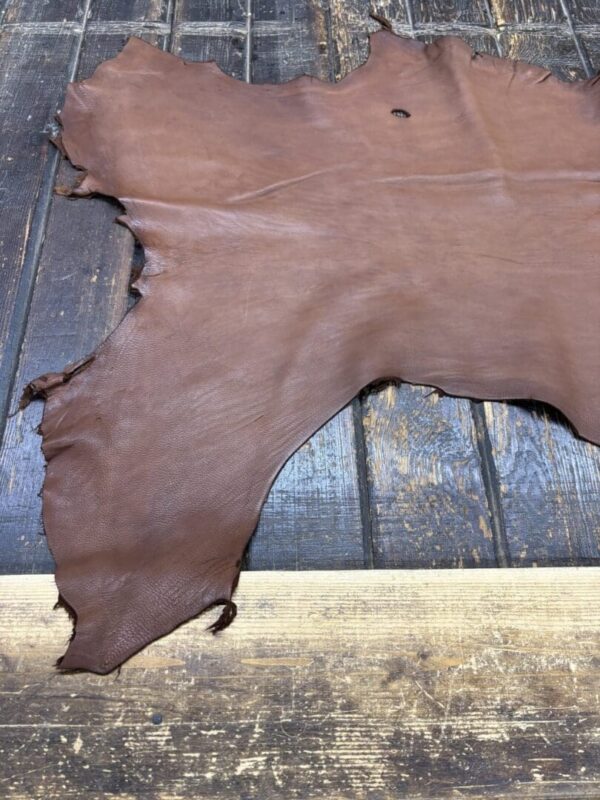 Brown leather hide on wooden surface.