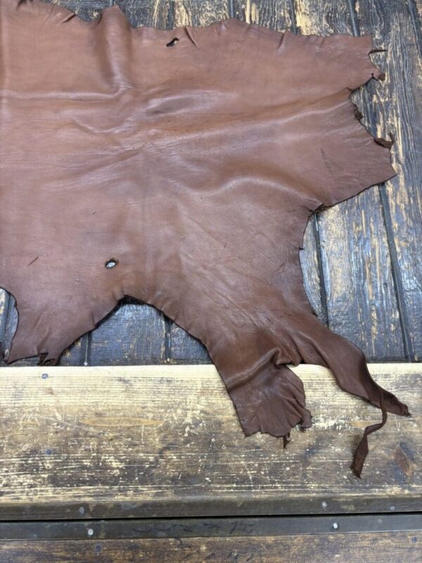 Brown leather hide on wooden surface.