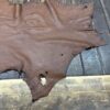 IMG_1906 Brown leather hide on wooden surface.