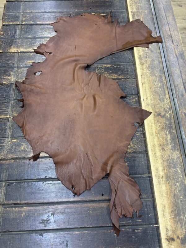 IMG_1908 Brown leather hide on wooden surface.