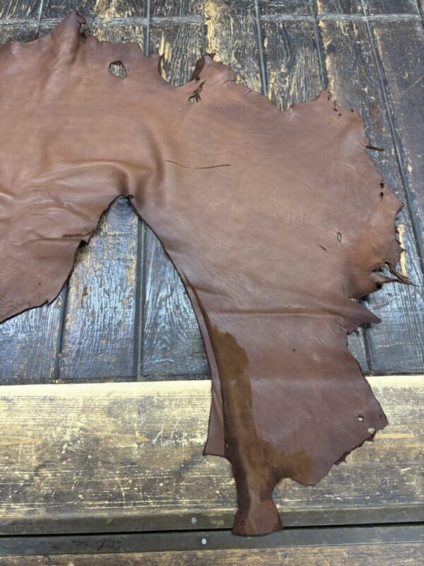 IMG_1910 Brown leather hide on wooden surface.