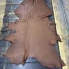 Brown leather hide on wooden surface.