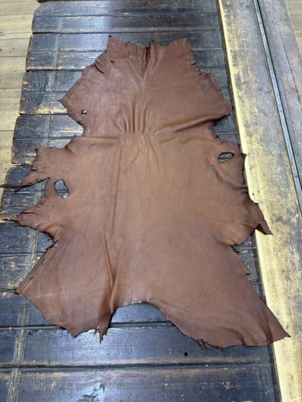 Brown leather hide on wooden surface.