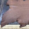 Brown leather hide on wooden surface.