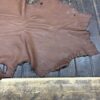 Brown leather hide on wooden surface.