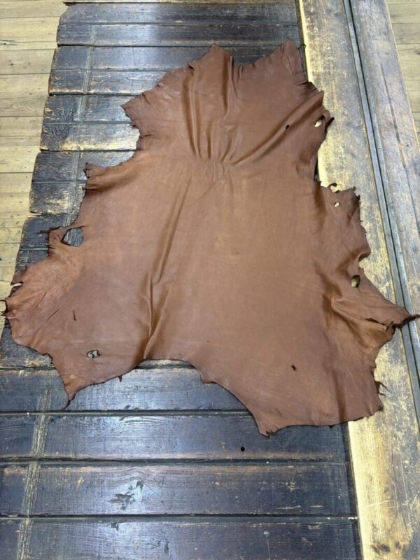 Brown leather hide on wooden surface.