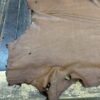 Brown leather hide on wooden surface.
