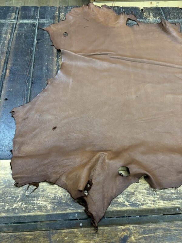 Brown leather hide on wooden surface.