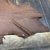 Brown leather hide on wooden surface.
