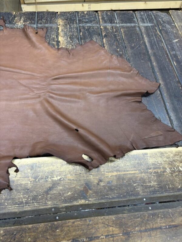 Brown leather hide on wooden surface.