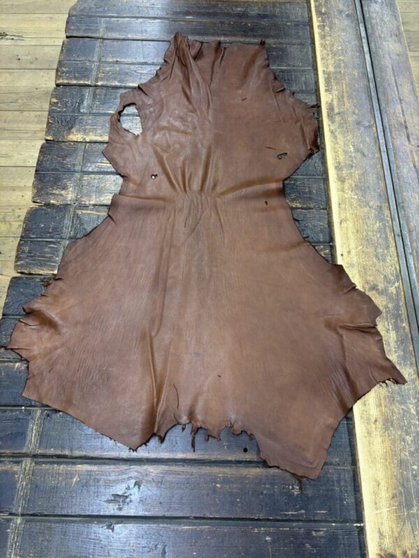 IMG_1921 Brown leather hide on wooden surface.