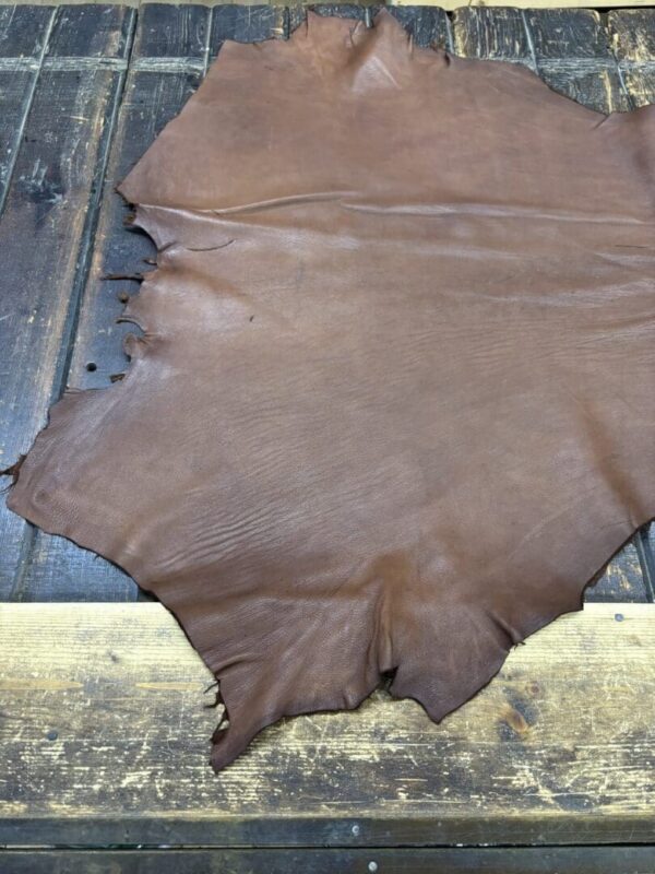 IMG_1922 Brown leather hide on wooden surface.