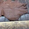 IMG_1923 Brown leather hide on wooden surface.